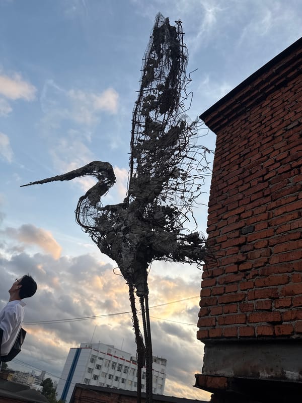 Moscow art opening with rooftop bird sculptures and a stormy sunset