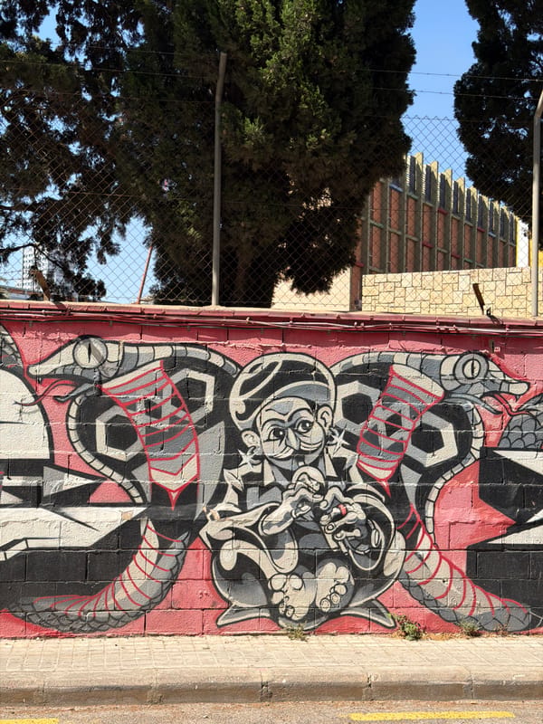 Street murals, scattered scooters, and soccer gear in an urban neighborhood