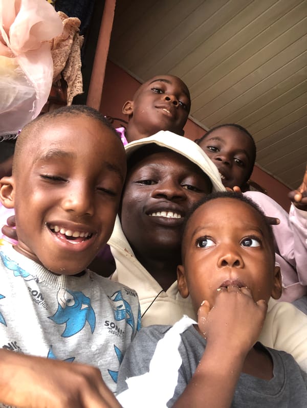 Group selfies with kids on a shaded porch in Ado, Nigeria