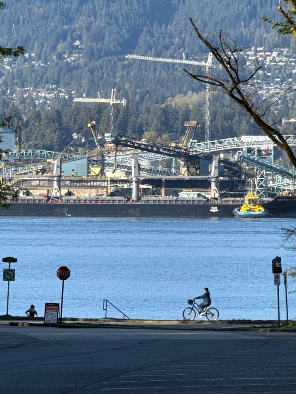 Cargo ship docked at Vancouver port with industrial infrastructure