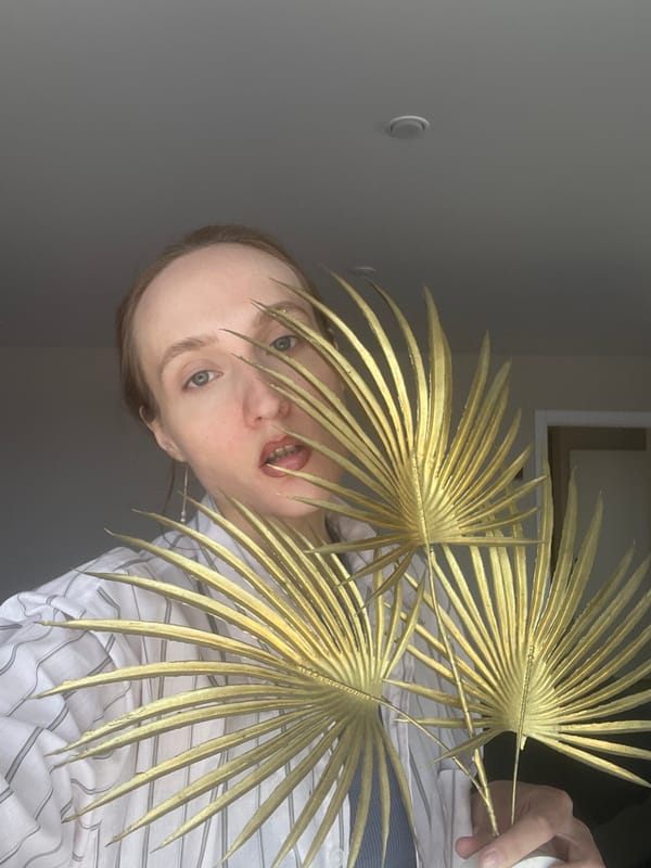 Person poses with golden palm fronds in Sepych, Russia