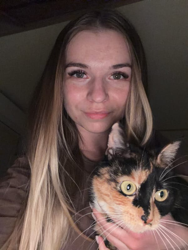 Woman holds calico cat in intimate moment