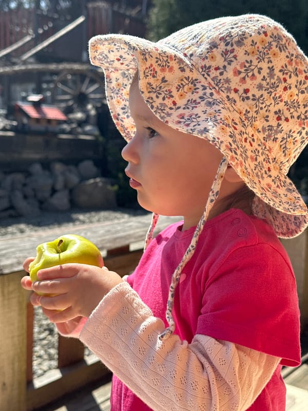 Child plays on swings in Disney hat in Wisła