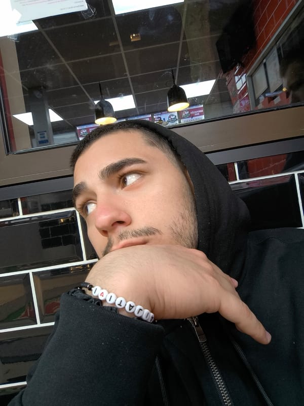 Man in black hoodie spotted wearing lettered bracelets in Strasbourg