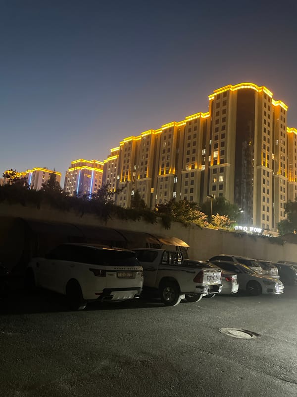 Dushanbe high-rises glow at dusk, street level quiet