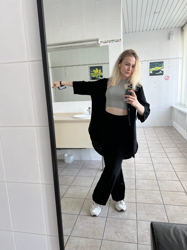Mirror selfies in a Khimki restroom, same outfit, same moment.