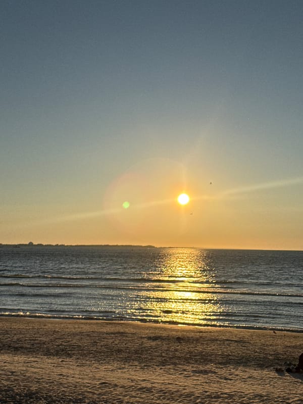 Tallinn beach glows under a clear summer sunset sky