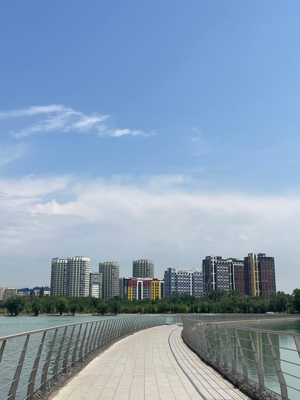 Almaty lakeside park in active use on a summer morning