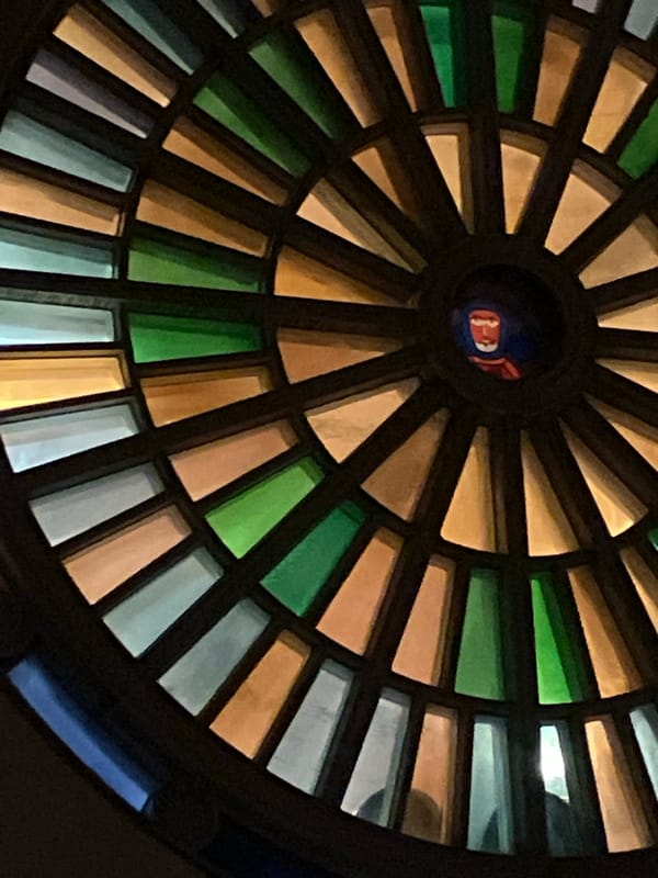 Architectural photography captures stained glass ceiling and ornate balcony