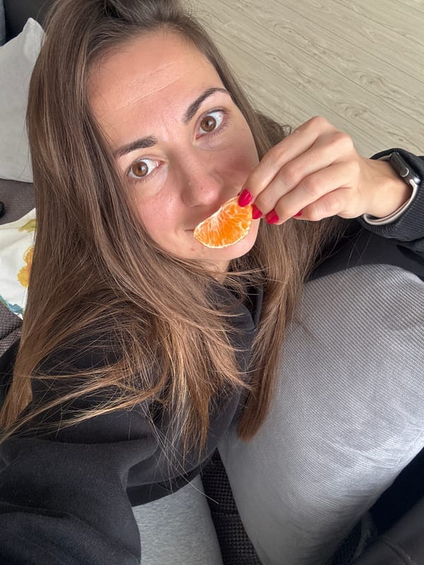 Person enjoys orange slice at home in Varna