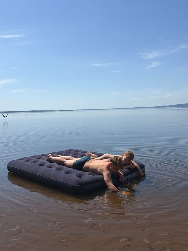 Children play on inflatable mattress in Zabegaevo waters