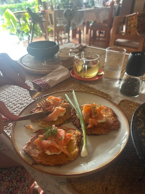 Diner enjoys salmon-topped potato pancakes in Thailand restaurant