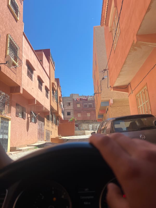 Vehicle passengers document street views in Ouaouizert, Morocco