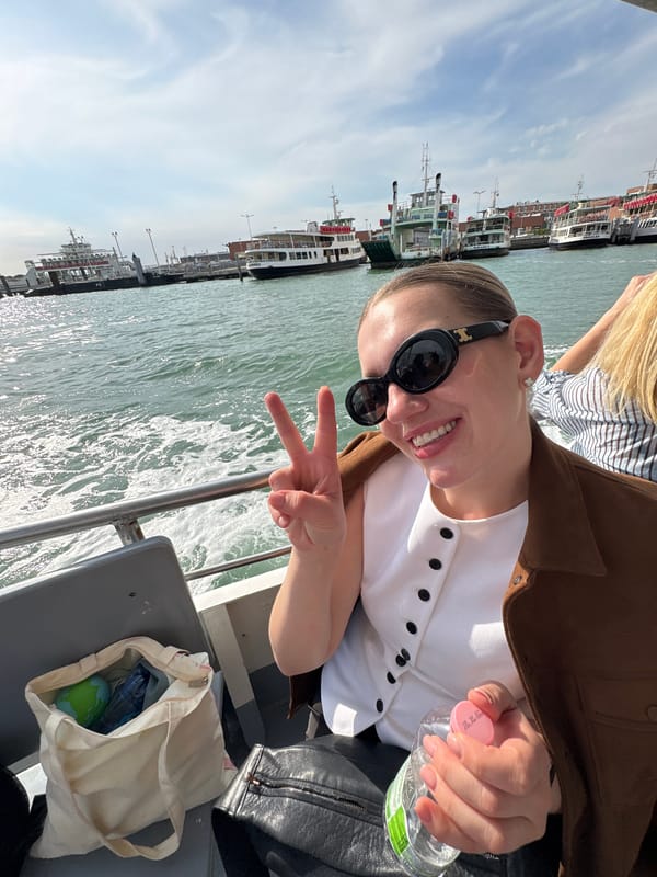 Tourists cruise Venice waterways, woman poses with peace sign