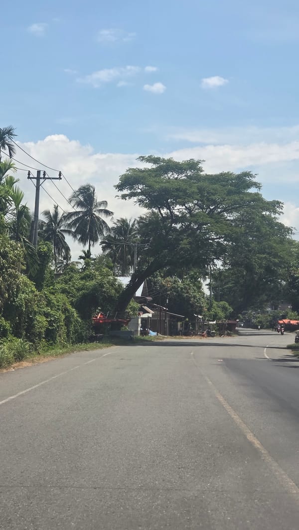 Car with open trunk, three people observed roadside Indonesia