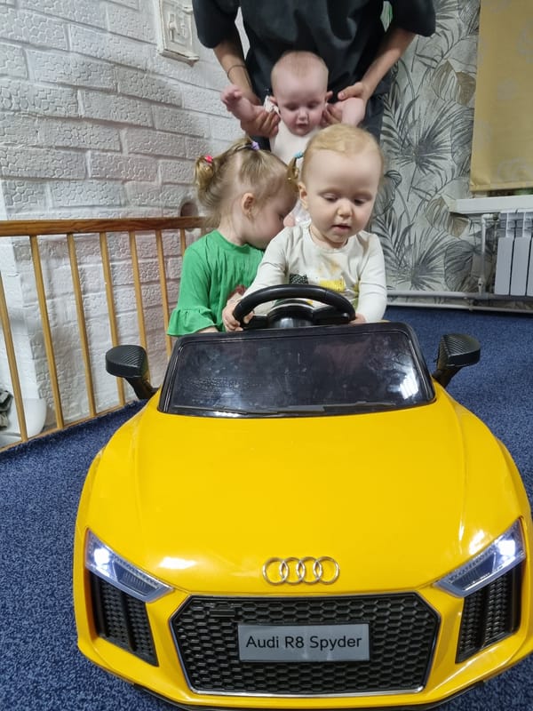 Children play with yellow toy Audi sports car