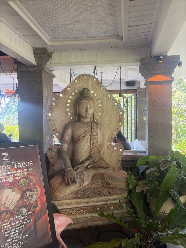 Ornate Buddha statue in a sunlit Ubud courtyard