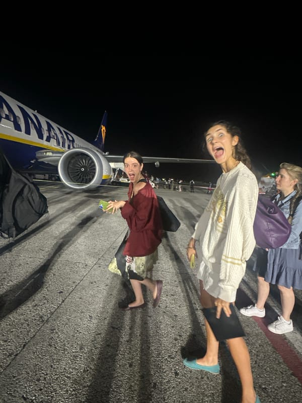 Young women pose playfully on Pisa airport tarmac