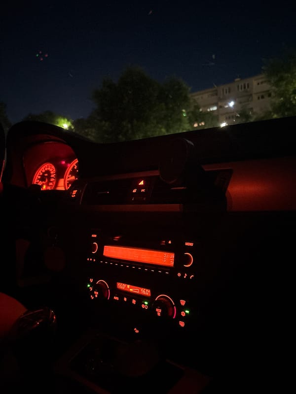 Parked outside a Lidl at night, killing time in the car