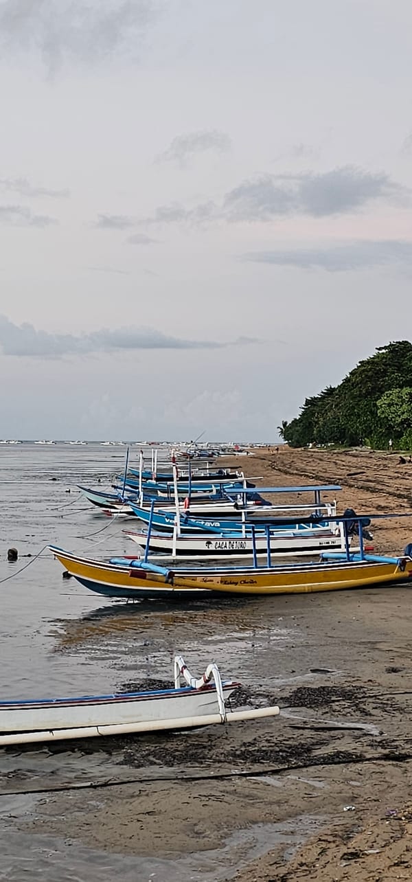 Evening coastal scenes captured in Denpasar featuring traditional boats, visitors