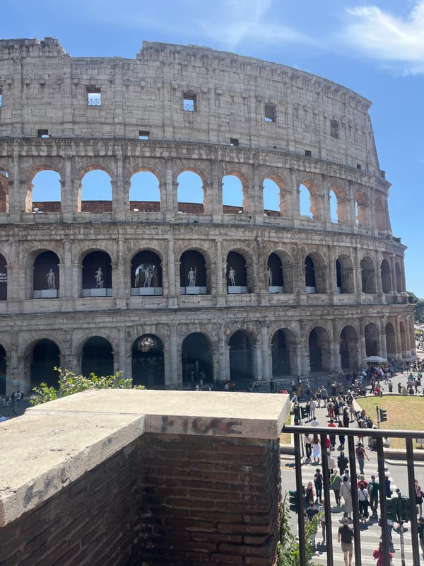 Tourist photographs document Colosseum under clear Rome skies