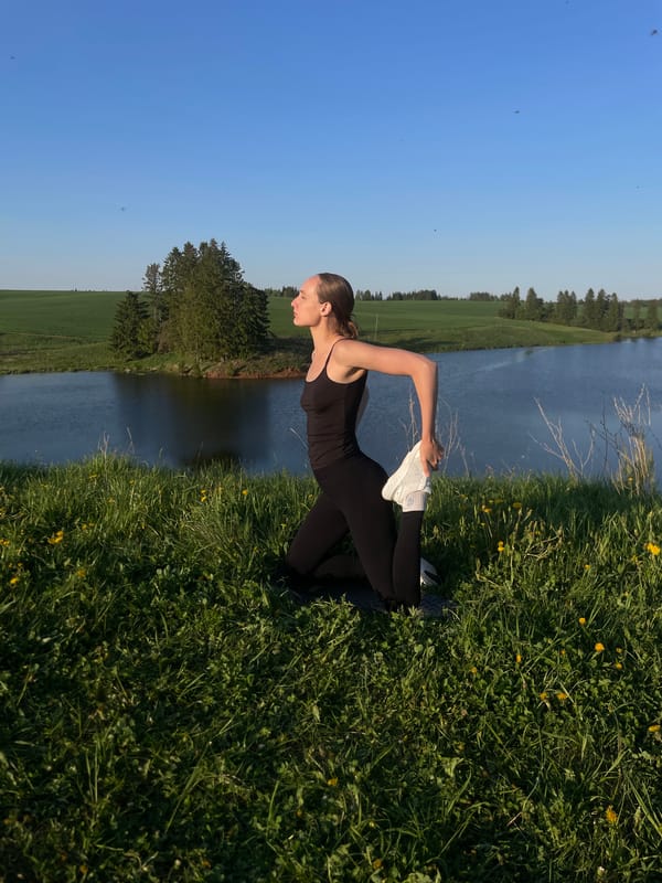 Woman performs outdoor yoga routine by water in Подшивалово