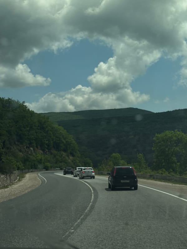 Three cars navigate winding road in Balaklava District, Ukraine