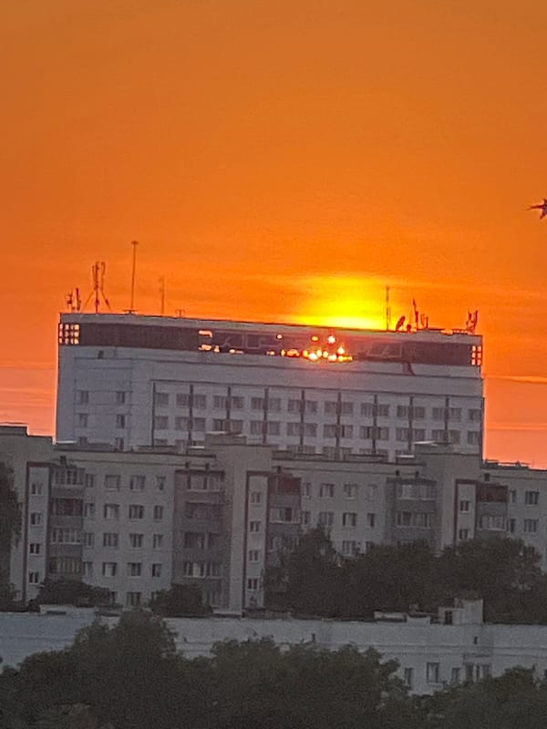 Golden hour over Minsk, sun setting behind city buildings