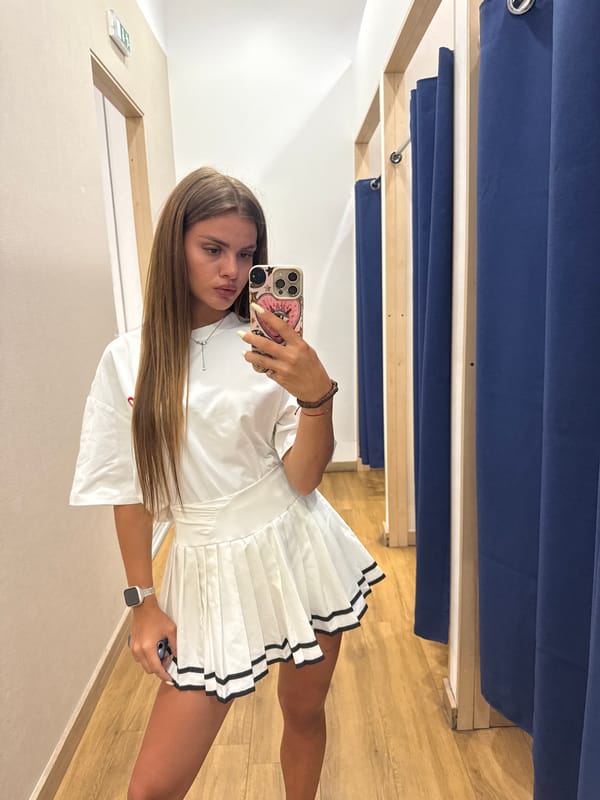 Fitting room mirror selfies in a white pleated skirt outfit