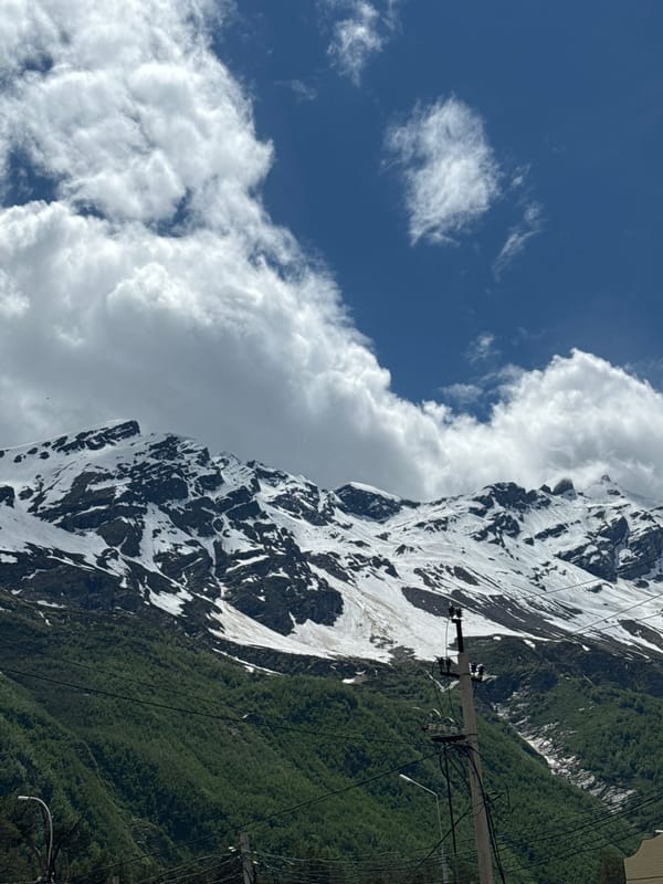 Snow-capped peaks and village paths in Terskol's Caucasus landscape