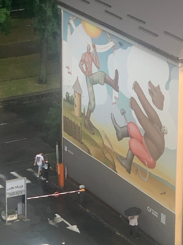 Rainy city day, street-level mural and wet rooftops