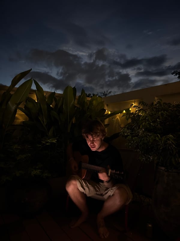 Evening guitar session on a plant-lined deck in Chiang Mai