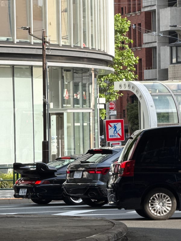 Black van parked near pedestrian crossing in Minato, Japan