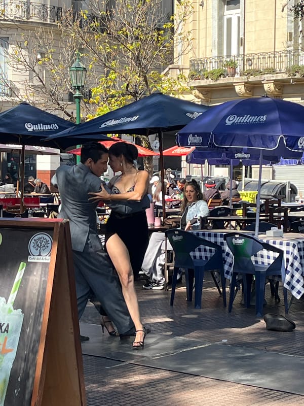 Tango couple dances in Buenos Aires street plaza