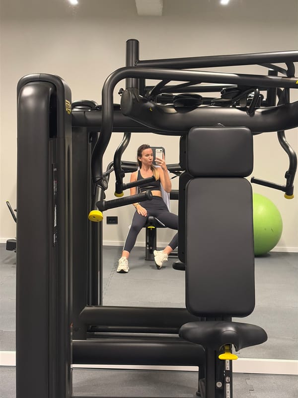 Woman documents gym session with smartphone selfies