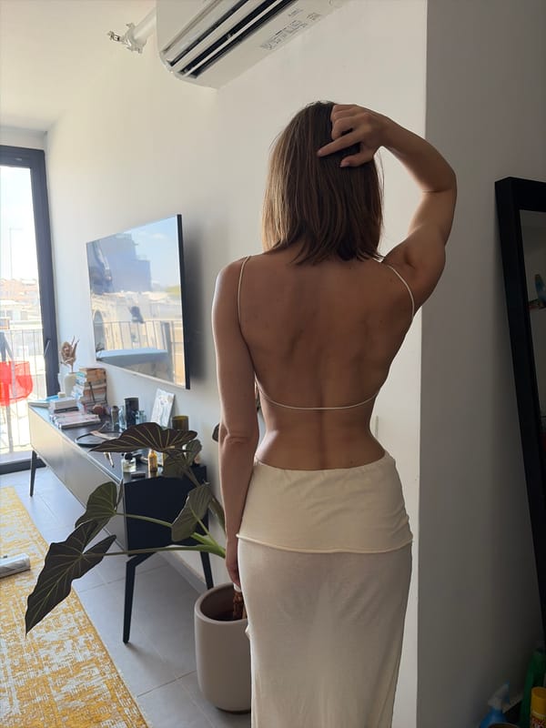 White low-back dress in a modern Tel Aviv apartment