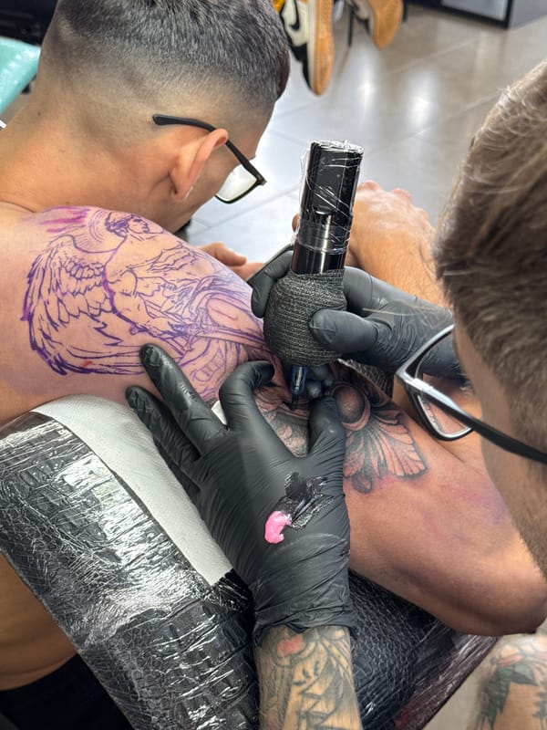 Tattoo artist applies koi fish design in Yaiza studio