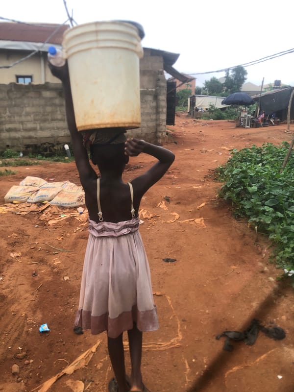 Girl carries water bucket in Ukwu-Abwa, Nigeria