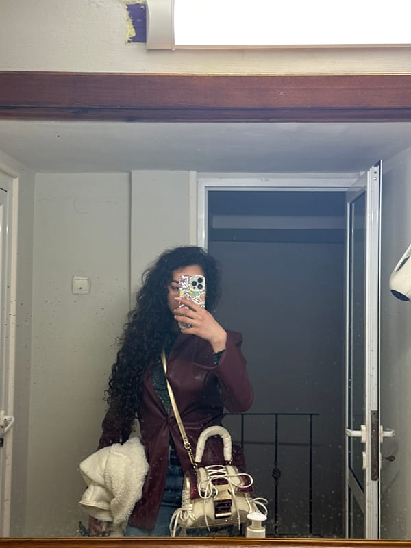 Mirror selfie captured showing person in maroon jacket