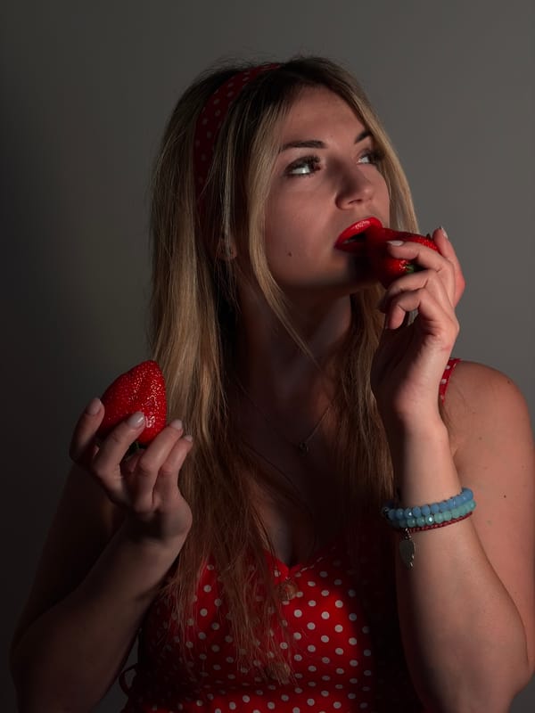 Woman in polka dot dress poses with strawberries in Budva