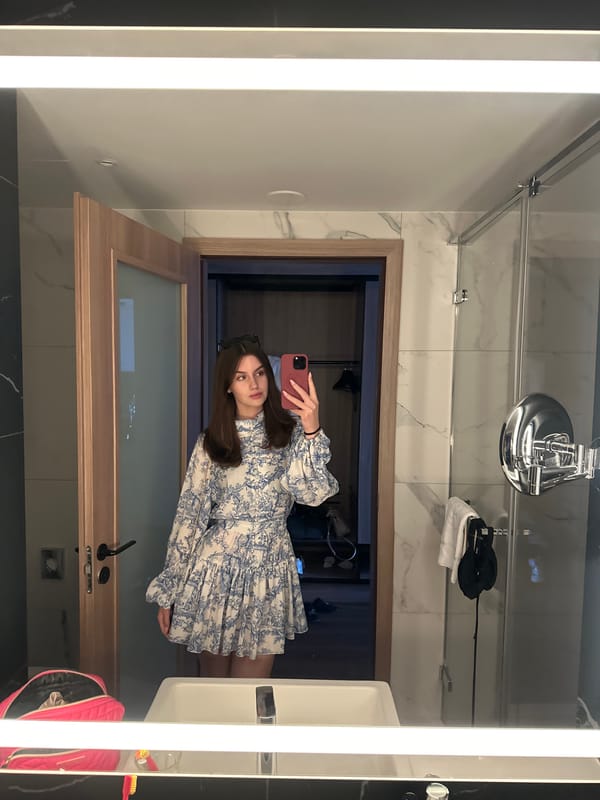 Mirror selfie in a marble bathroom, blue floral dress