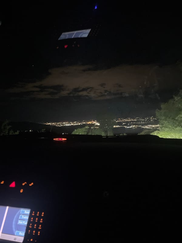 Nighttime city lights reflection captured from vehicle in Asenovgrad