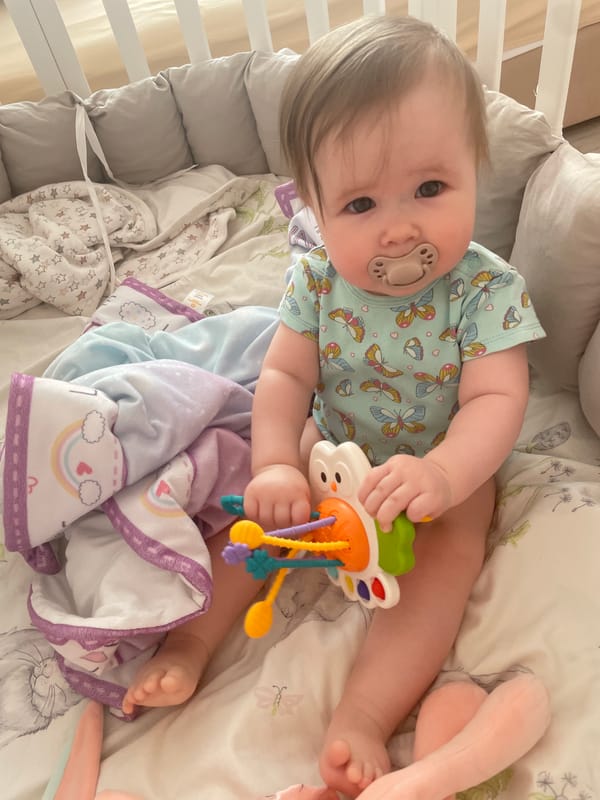 Baby in butterfly bodysuit observed in crib in Chaikovsky