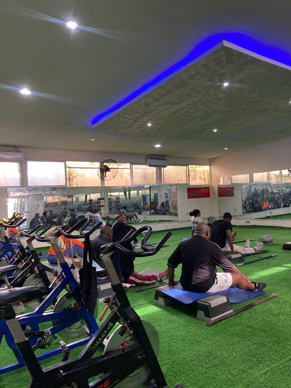 Morning fitness class exercises on green turf in Gwarinpa gym