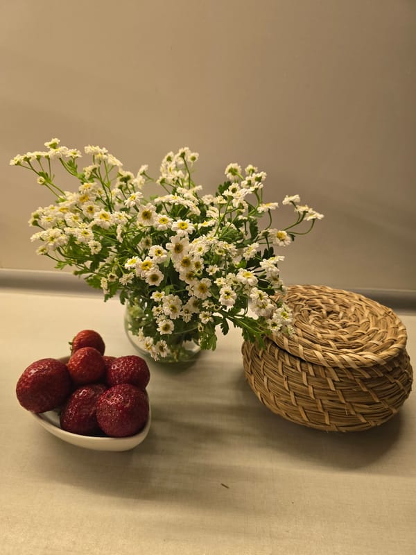 Fresh strawberries and daisies arranged on a kitchen surface