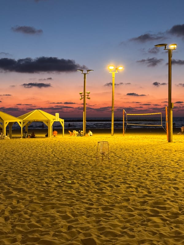 Tel Aviv beach at dusk, sky fading through pink and orange