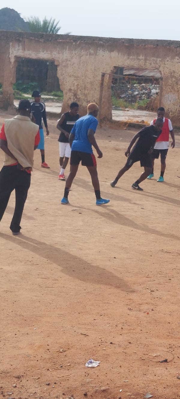 Informal football on a dirt field in Bukuru, Nigeria