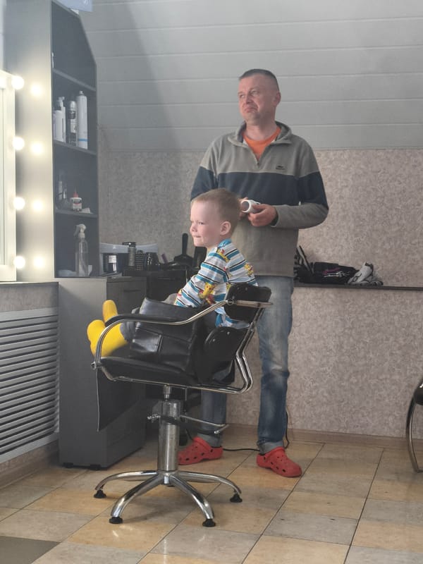 Boy receives haircut at Russian salon
