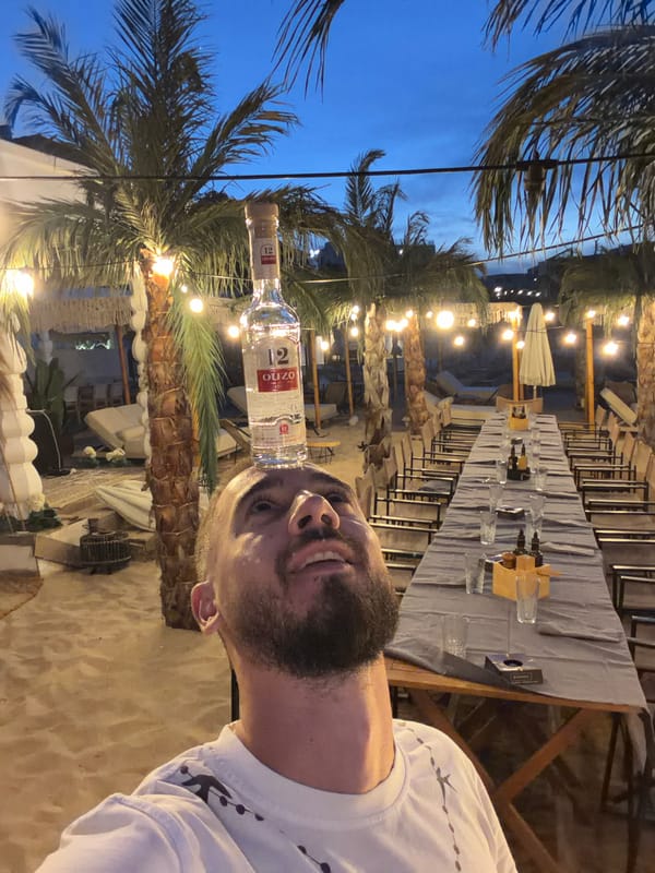Beach dinner setup at dusk with a side of Ouzo tricks