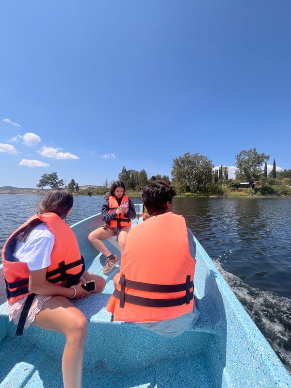 Three youths in life vests boat on Valsequillo Lake